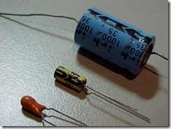 Figure 2.6. Capacitors have just two wires, like resistors. The larger can capacitors contain rolled-up foil and plastic in layers. The sm